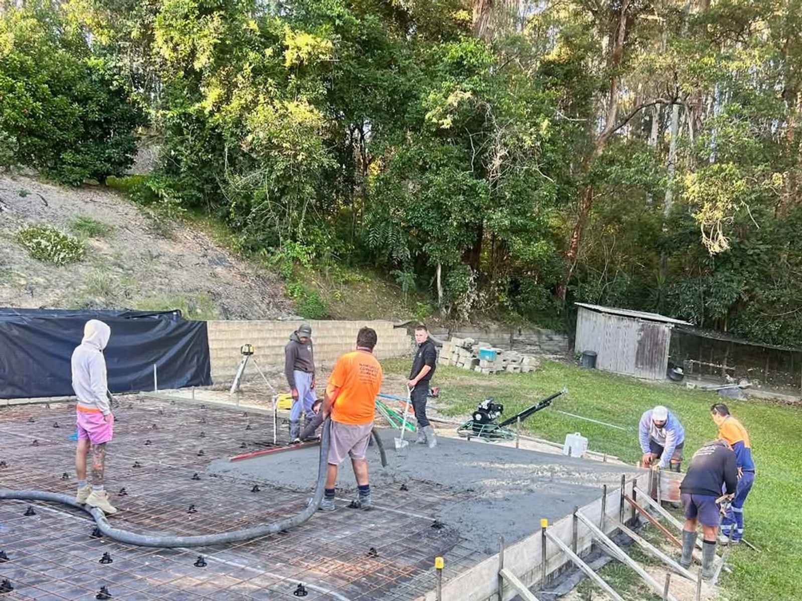 The Apex crew on site mid-pour, working a backyard slab in the bush near Macksville NSW